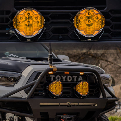 Pair of SUPAREE HELM 7-inch LED driving lights with amber covers mounted on a Toyota truck.