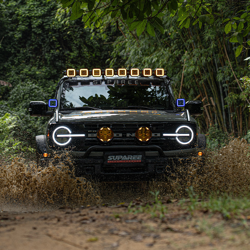 Off-road vehicle crossing water with SUPAREE HYPER 5 pod lights on the roof and beside the windshield.