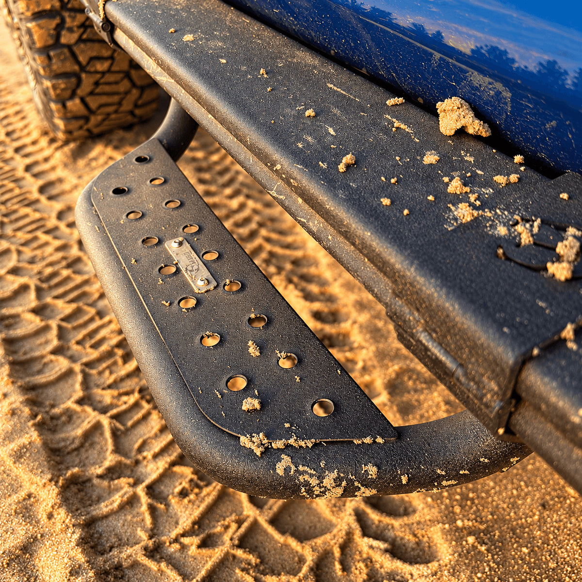 Close-up of the perforated tread and curved tube of a Jeep Gladiator JT side step.