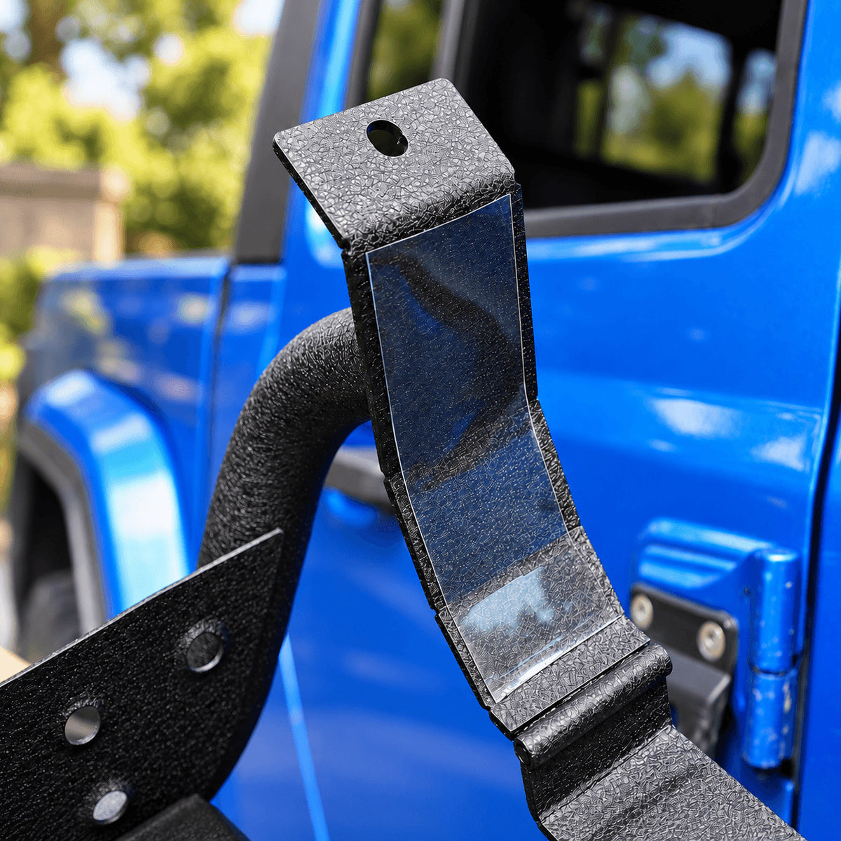 Inside face of a black side-step bracket, showing its protective film and upper bolt hole.