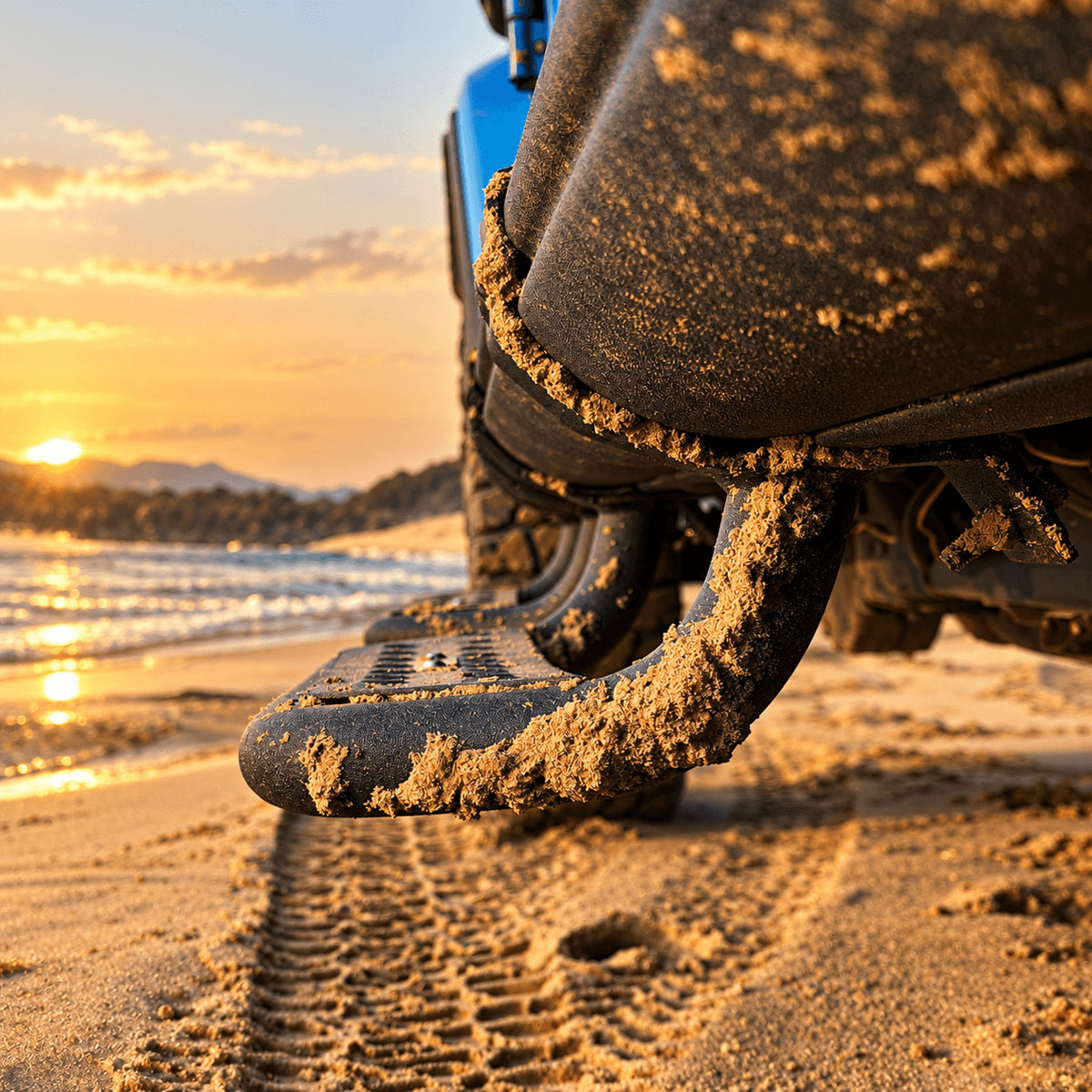 Low side view of a black step extending below the rock rail of a Jeep Gladiator JT on sand.
