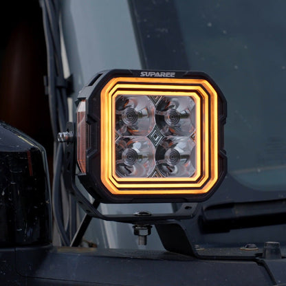 Close-up of a SUPAREE HYPER 5 RGBW LED pod light with amber three-layer backlighting.