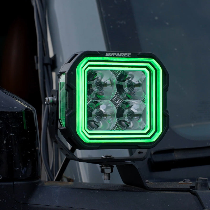 Close-up of a SUPAREE HYPER 5 RGBW LED pod light with green three-layer backlighting.