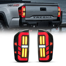 Smoked LED tail light pair for 2016-2023 Toyota Tacoma, shown illuminated and installed on the truck.