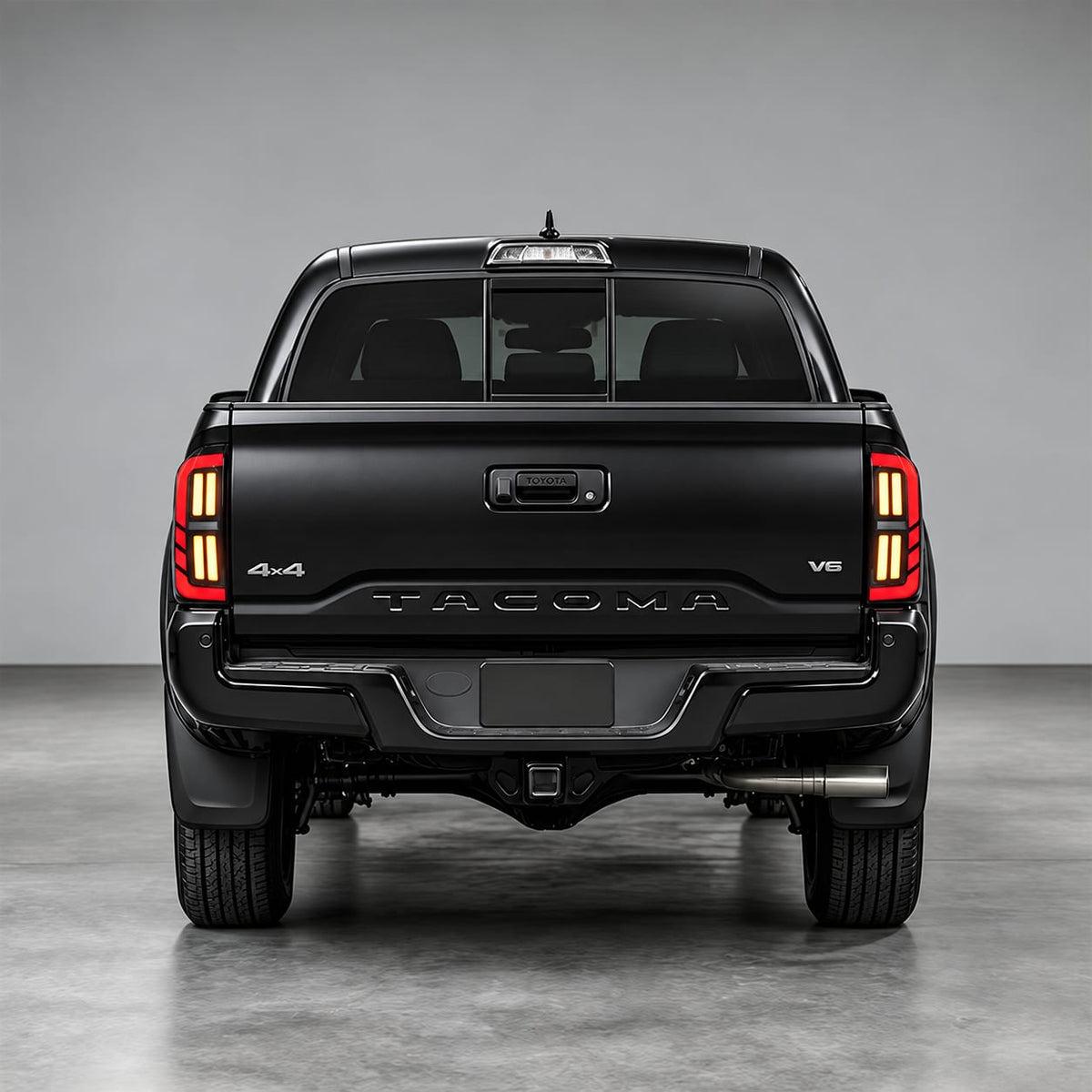 Rear view of a Toyota Tacoma with smoked LED tail lights for 2016-2023 models illuminated in red and amber.