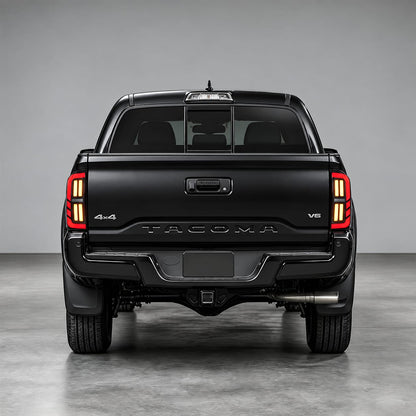 Rear view of a Toyota Tacoma with smoked LED tail lights for 2016-2023 models illuminated in red and amber.