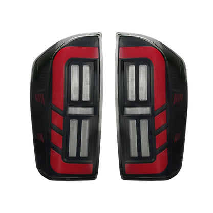 Unlit smoked LED tail light pair for 2016-2023 Toyota Tacoma, showing black housings and red lens details.