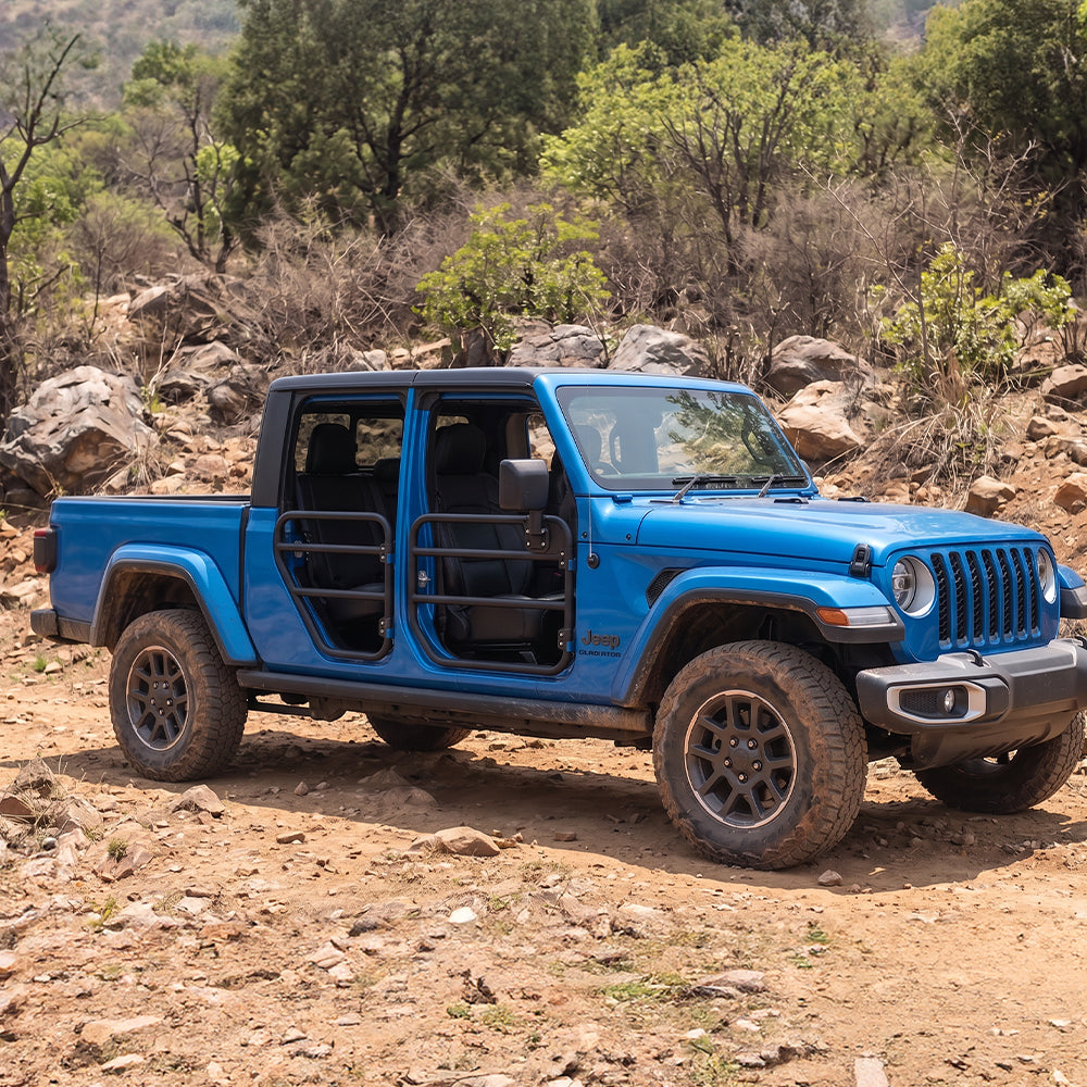 Blue Jeep Gladiator JT with SD1 SERIES tube doors parked on rocky t