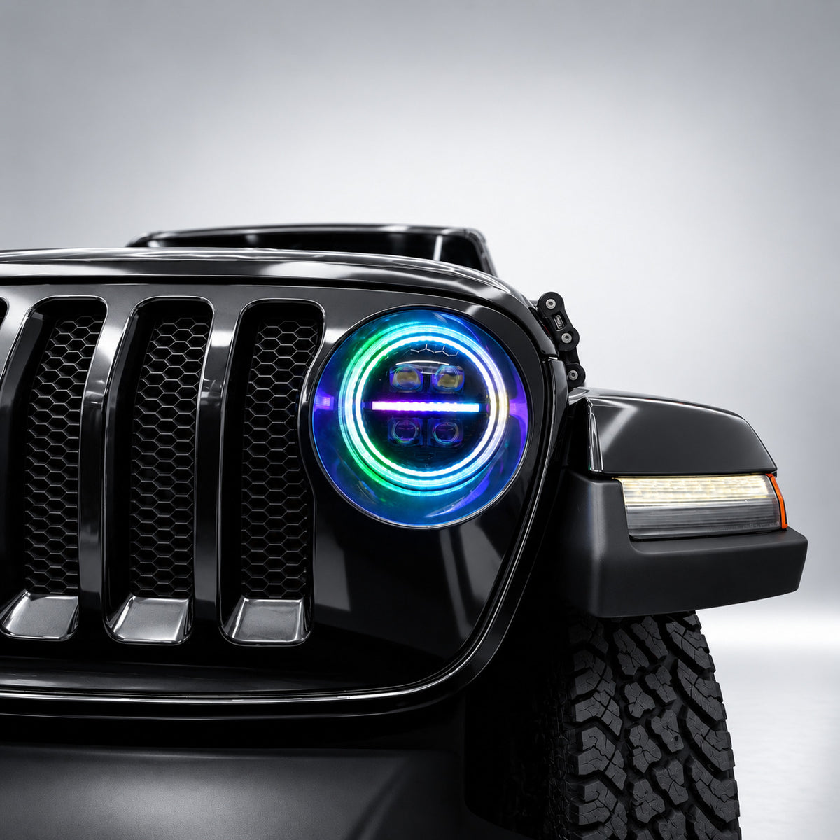 Close-up of a 9-inch Jeep RGB LED headlight with blue, green and violet halo lighting