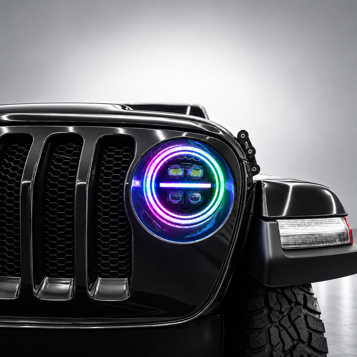 Close-up of a 9-inch Jeep RGB LED headlight with rainbow spectrum dual halo rings