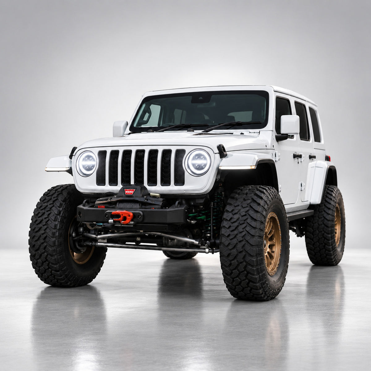 White Jeep Wrangler JL with bright white quad-projector LED headlights, front three-quarter view