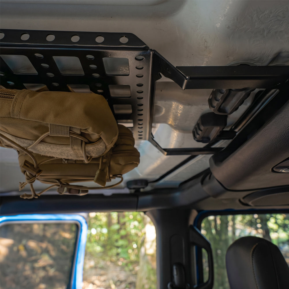 Interior view of Jeep Wrangler JL overhead storage rack showing upward curved design for maximum headroom and clear rearview visibility