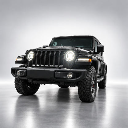 Black Jeep Wrangler JL with white LED headlights illuminated, front three-quarter view