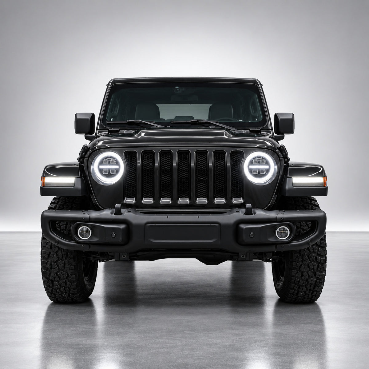 Black Jeep Wrangler JL front view with white DRL halo rings and center light bars